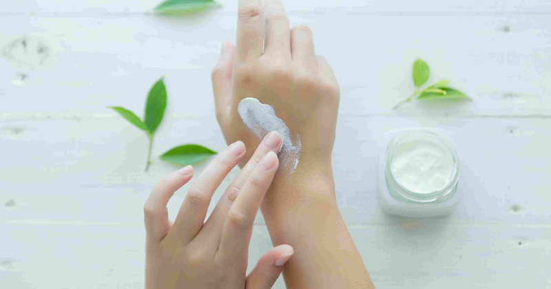 a girl applying moisturizing cream on her hand