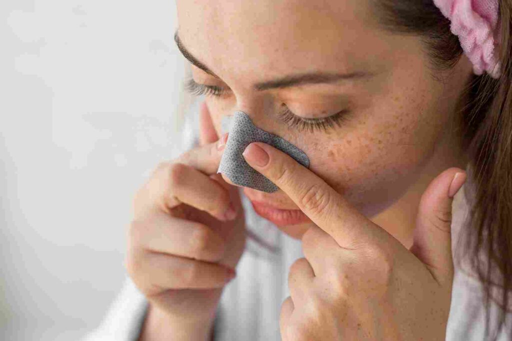 a girl putting nose patch on her nose