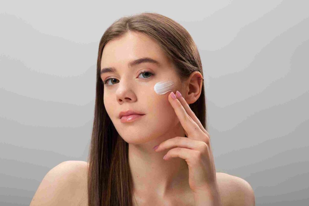 a girl applying sunscreen on her face